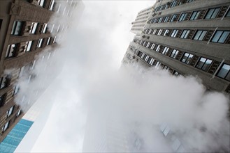 Low angle view of skyscraper and steam