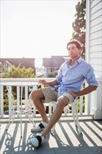 Portrait of young man relaxing on balcony