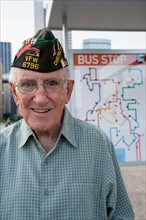 Portrait of senior man standing at bus stop