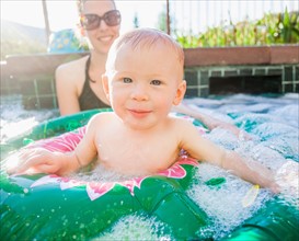Baby boy (18-23 months) playing in swimming pool with his mother