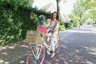 Mother with her baby daughter (12-17 months) on bicycle