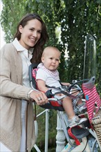 Mother with her baby daughter (12-17 months) on bicycle