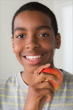 Boy (14-15) holding apple