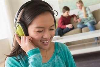 Girl (16-17) listening to music wearing headphones