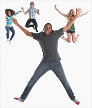 Studio shot of four friends (12-13,14-15) jumping on white background