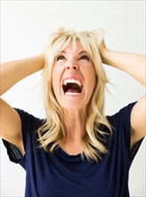 Studio portrait of blonde woman screaming