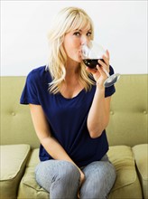 Woman relaxing on sofa and drinking wine