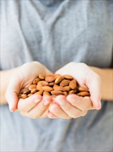 Hands holding almonds, studio shot