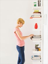 Young woman standing near bookshelf