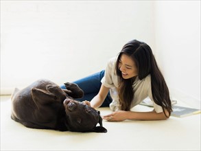 Woman with dog lying on floor