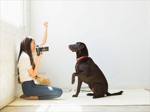 Woman photographing dog in studio