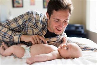 Father playing with baby boy (2-5 months)