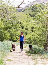 Woman with two dogs hiking in landscape