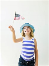 Portrait of blonde girl (4-5) holding American flag