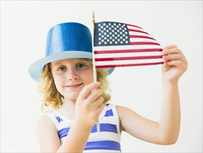 Portrait of blonde girl (4-5) holding American flag