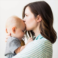 Studio portrait of mother kissing baby boy (6-11 months)