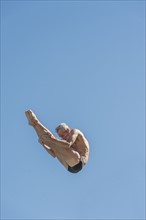 Athletic swimmer jumping.