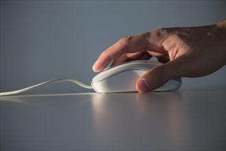Studio shot of hand using computer mouse.