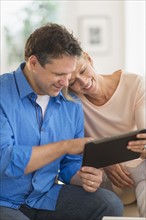 Couple using tablet pc at home.