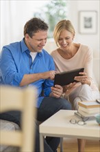 Couple using tablet pc at home.