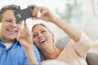 Couple taking self-portrait photo with smartphone.