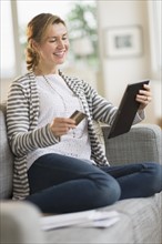 Woman holding tablet pc and credit card.