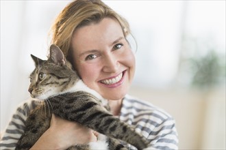 Portrait of woman holding cat.