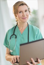Portrait of female doctor using laptop.