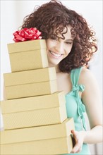 Woman holding stack of gifts.