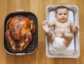 Baked turkey and baby girl (2-5 months) in baking dish.