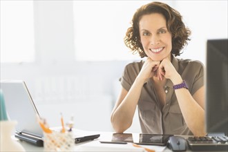 Portrait of business woman sitting at desk.