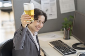 Business woman holding glass of beer.
Photo : Jamie Grill