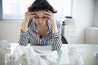 Overworked businesswoman sitting at desk.
Photo : Jamie Grill