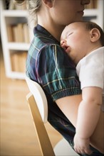 Baby girl (2-5 months) sleeping in mother's arms.
Photo : Jamie Grill