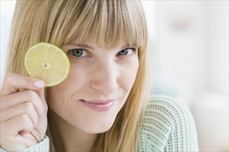 Portrait of woman holding slice of lime.
Photo : Jamie Grill