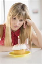 Woman looking at birthday cupcake.
Photo : Jamie Grill