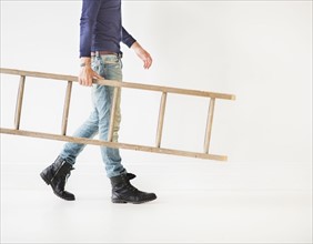 Low section of man carrying ladder.
Photo : Daniel Grill