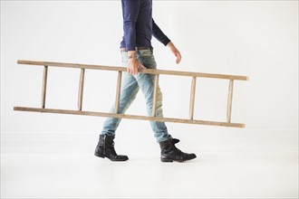 Low section of man carrying ladder.
Photo : Daniel Grill