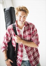 Portrait of man carrying guitar bag.
Photo : Daniel Grill