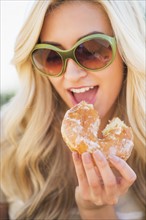 Portrait of teenage girl (16-17) eating doughnut.
Photo : Daniel Grill