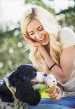 Portrait of teenage girl (16-17) with dog licking ice cream.
Photo : Daniel Grill