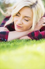 Teenage girl (16-17) sleeping on grass.
Photo : Daniel Grill
