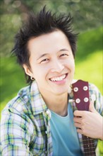 Portrait of teenage boy (16-17) playing guitar in park.
Photo : Daniel Grill