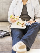 Teenage boy(16-17) eating sandwich and watching tv.
Photo : Daniel Grill