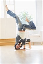 Teenage boy (16-17) dancing in living room.
Photo : Daniel Grill