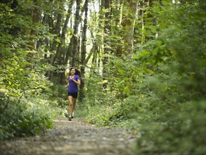 Young women jogging in forest. USA, Oregon, Portland.