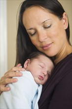 Portrait of mother holding newborn baby (0-11 months).