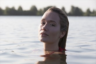 Woman relaxing in lake, Looking at camera. Netherlands, Gelderland, De Rijkerswoerdse Plassen