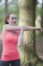 Woman stretching in forest. The Netherlands, Erp.
Photo : Mark de Leeuw
