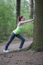 Woman stretching in forest. The Netherlands, Erp.
Photo : Mark de Leeuw